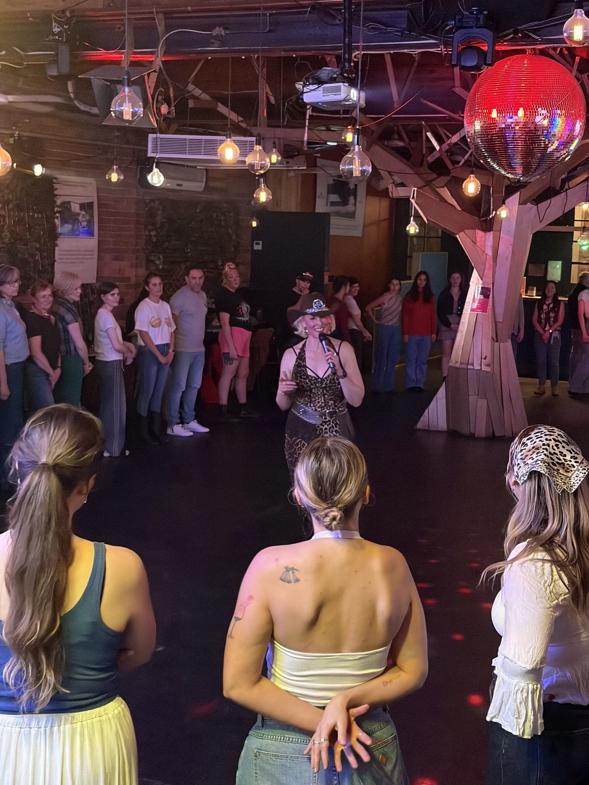 A whole room up line dancing together at a Boot Scooting Society corporate event