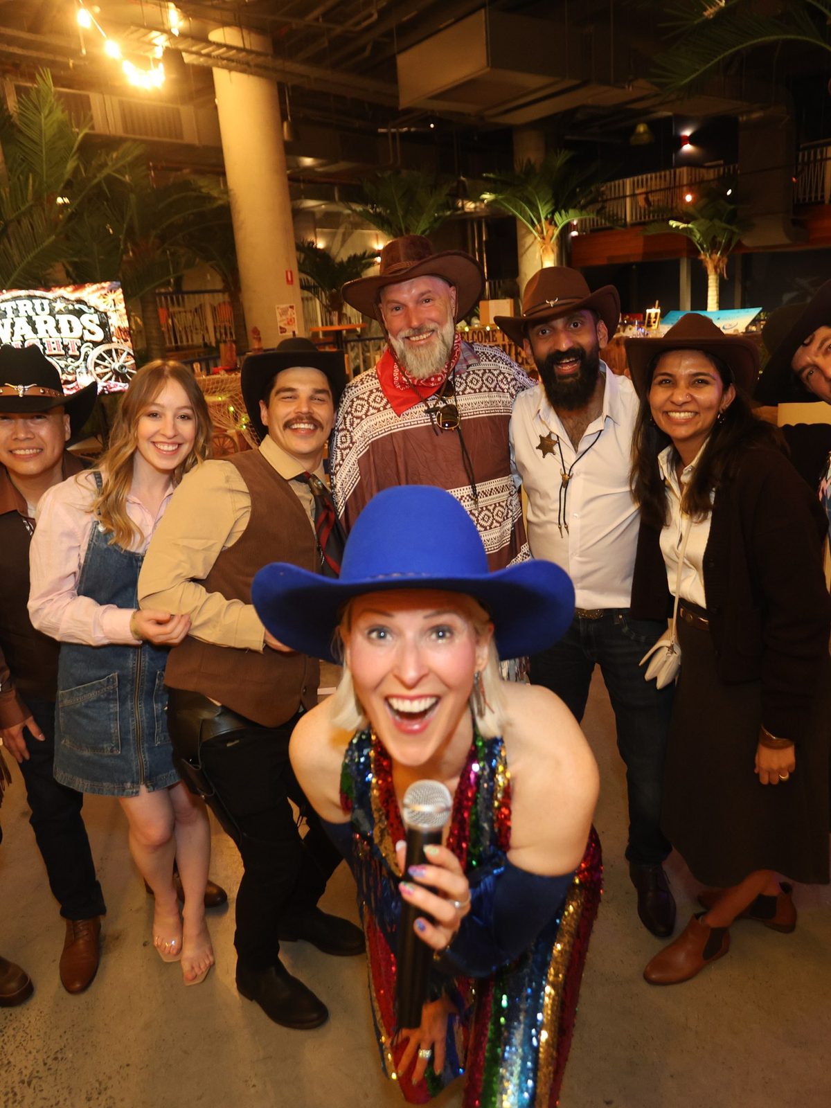 Kirsten Mann hosting a company boot scootin' night, front and centre with the whole team in cowboy hats