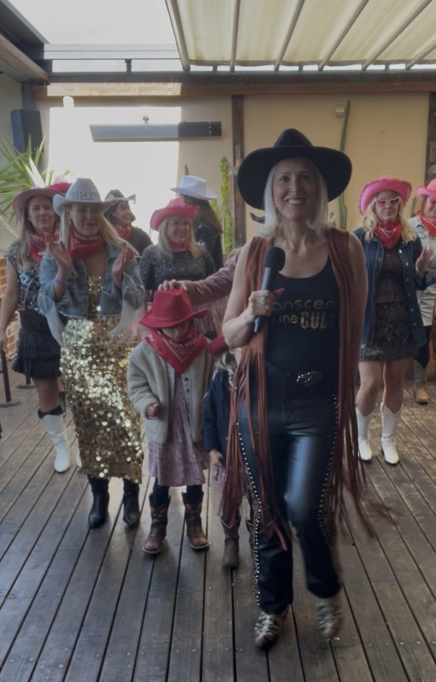 Kirsten Mann in a brown fringe jacket leading a private party group