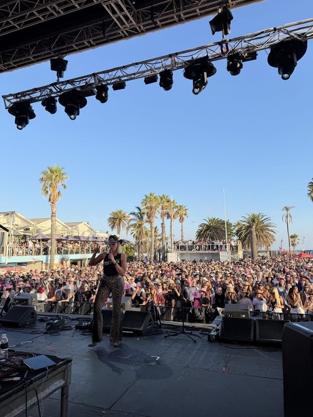 Kirsten Mann on the festival main stage leading a huge crowd in line dancing
