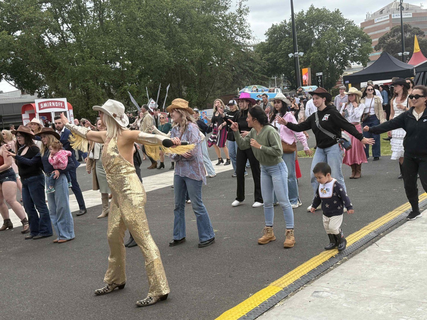 A huge festival crowd line dancing with Boot Scooting Society